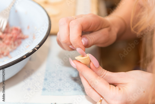 Sculpt dumplings. Traditional Russian cuisine. National dish. Hand molding. Dough with meat. Woman sculpt dumplings with her hands.