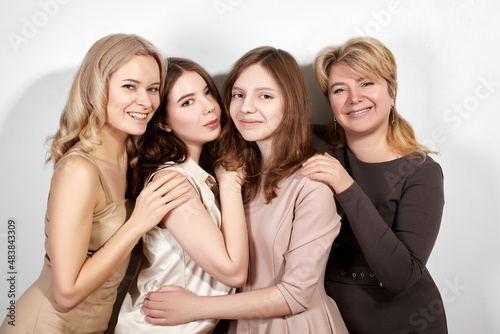 Happy Family of Mother with Three Daughters on Light Grey Background. Fashion Style Studio Portrait.