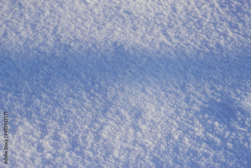 textured snow background with blue shadow in sunny winter day 
