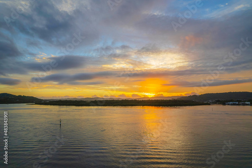 Sunrise waterscape with a mix of low, medium and high clouds © Merrillie