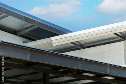 wood looking metal sheet white trim roof decoration gable, corbel, louver with white horizontal siding on a luxury home with blue sky background