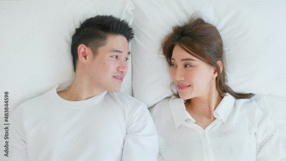 Portrait of Asian new marriage couple lying on bed and look each other. Portrait of Asian new marriage couple lying on bed and look each other.