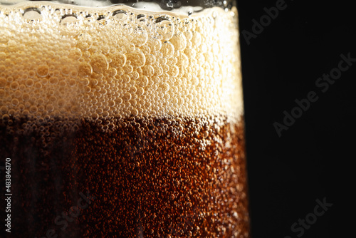 Glass of refreshing soda drink on black background, closeup