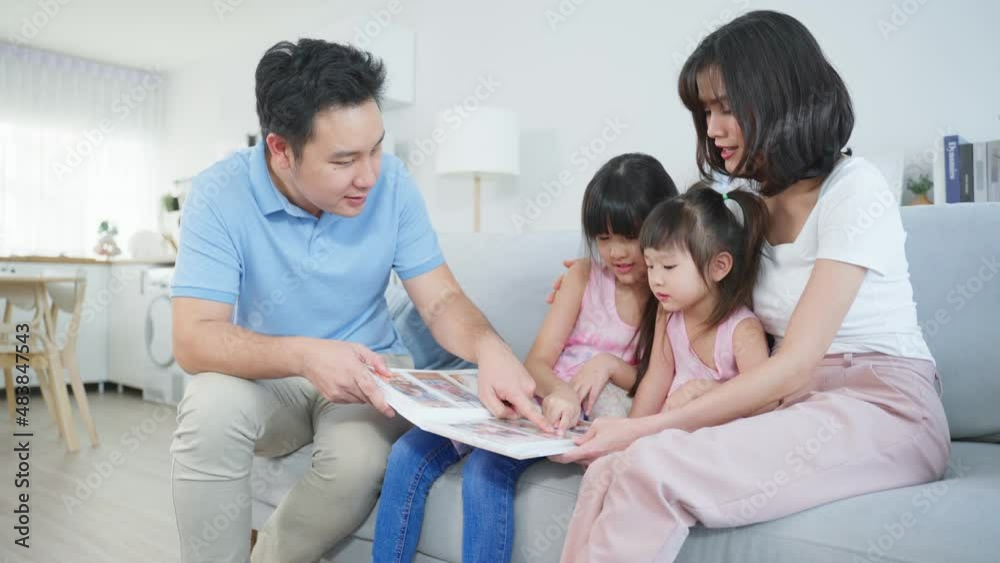 Asian family look at photographs on old picture album recalls the past. Asian family look at photographs on old picture album recalls the past.