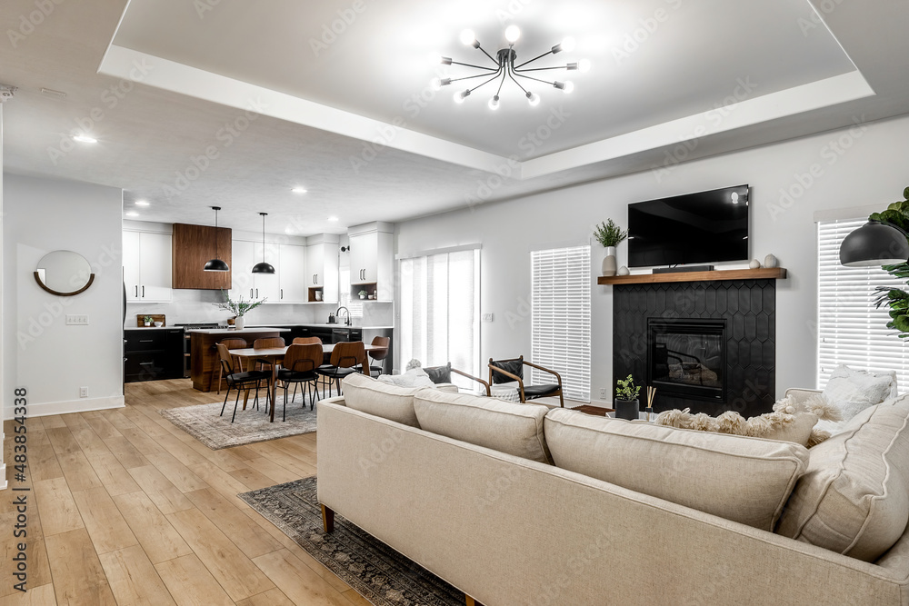 Fototapeta premium Midcentury modern kitchen with black and white cabinets, matte black fixtures, white quartz countertops and backsplash and walnut wood furniture interior design