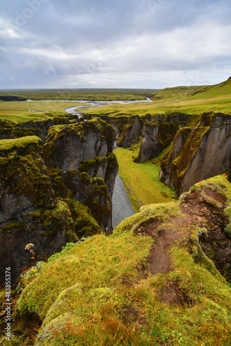 Green and beautiful Fjaðrárgljúfur canyon reaching the coastal plains near Kirkjubæjarklaustur village, South Coast of Iceland 