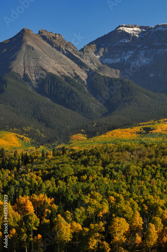 Late afternoon light on fall colors up the slopes of Whitehouse Mountain and Corbett Peak and ridge on the Sneffels Range of the San Juan mountains, from a country road near Ridgway, Colorado, USA photo
