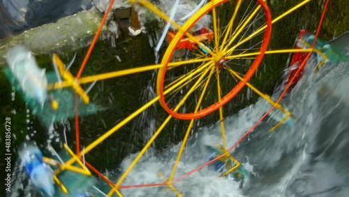 Close up of water wheel spinning around in irrigation channel photo