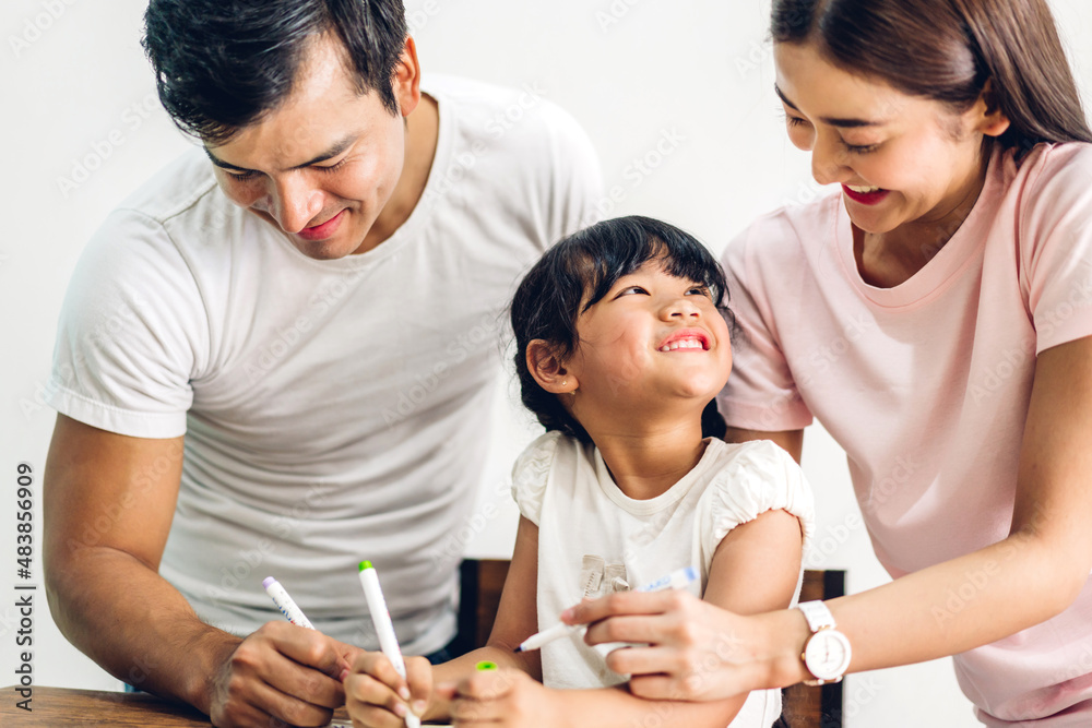 Portrait happy love asian family father and mother with little asian girl learn and study on table.Mom and dad with asian young girl writing with book make homework in homeschool at home.Education Portrait happy love asian family father and mother with little asian girl learn and study on table.Mom and dad with asian young girl writing with book make homework in homeschool at home.Education