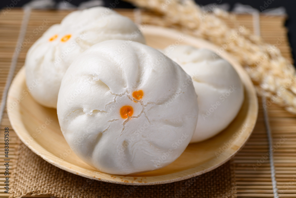 Steamed Chinese bun stuffed with minced pork, egg yolk or sweet on natural plate, Asian food Steamed Chinese bun stuffed with minced pork, egg yolk or sweet on natural plate, Asian food
