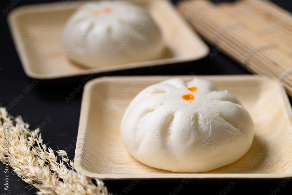 Steamed Chinese bun stuffed with minced pork, egg yolk or sweet on natural plate, Asian food Steamed Chinese bun stuffed with minced pork, egg yolk or sweet on natural plate, Asian food