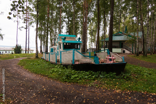 wooden old boat on land as decor, recreation center in the forest in summer