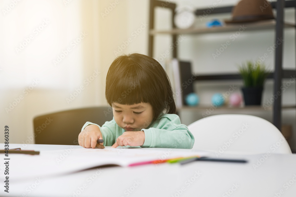 Happy asian boy painting with crayon and colored pencil in living room at home. Little boy doing homework Practice the skills of drawing and painting. Happy asian boy painting with crayon and colored pencil in living room at home. Little boy doing homework Practice the skills of drawing and painting.