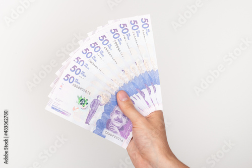 Hand holding colombian money