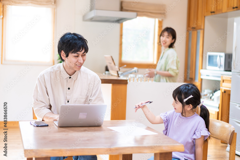 テレワークをする夫婦と子供 テレワークをする夫婦と子供