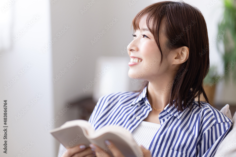 ソファに座って読書する女性 ソファに座って読書する女性