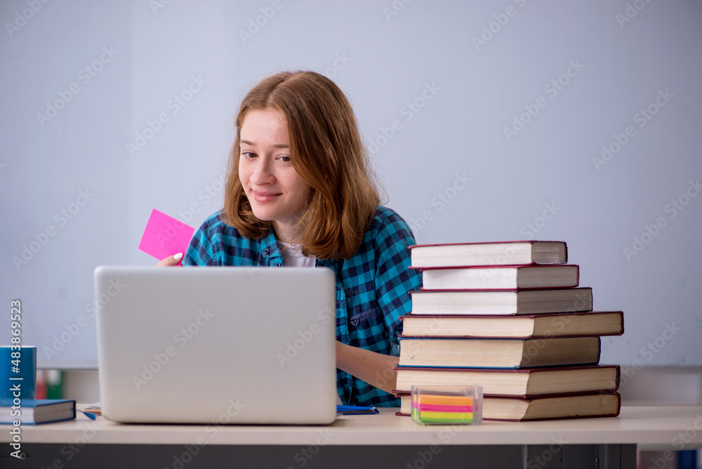 Young female student preparing for exams in the classroom Young female student preparing for exams in the classroom