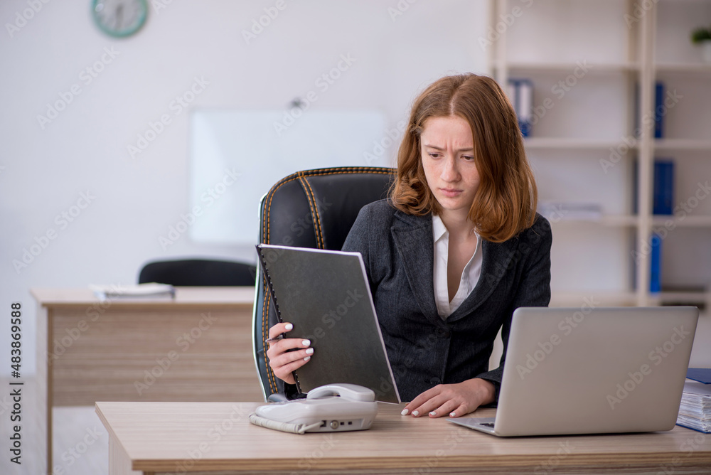Young female employee working in the office Young female employee working in the office