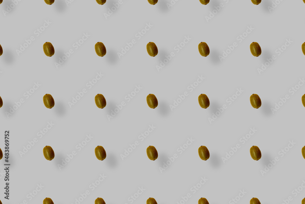 Colorful fruit pattern of fresh kiwi on grey background with shadows. Top view. Flat lay. Pop art design Colorful fruit pattern of fresh kiwi on grey background with shadows. Top view. Flat lay. Pop art design