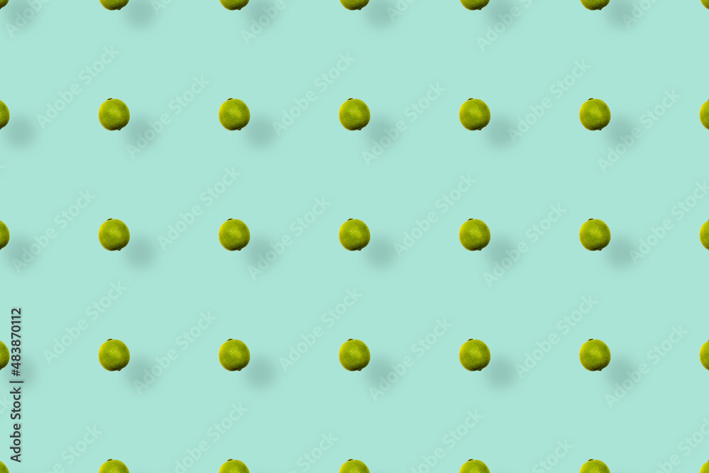 Colorful fruit pattern of fresh limes on green background with shadows. Top view. Flat lay. Pop art design Colorful fruit pattern of fresh limes on green background with shadows. Top view. Flat lay. Pop art design