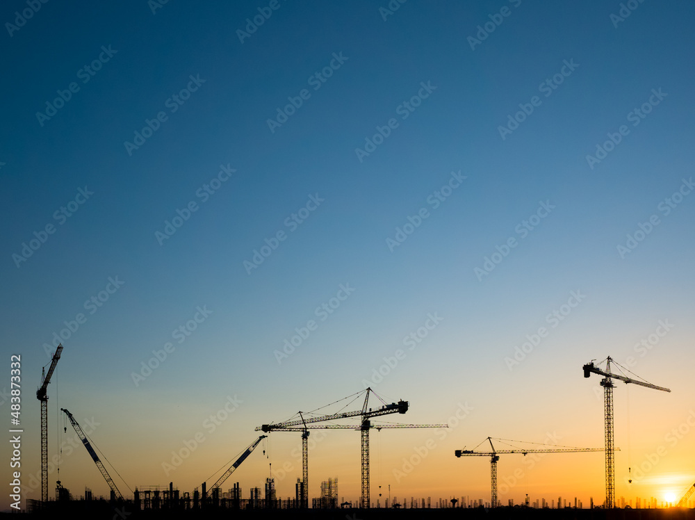Cranes on a construction site, Silhouette of sunset