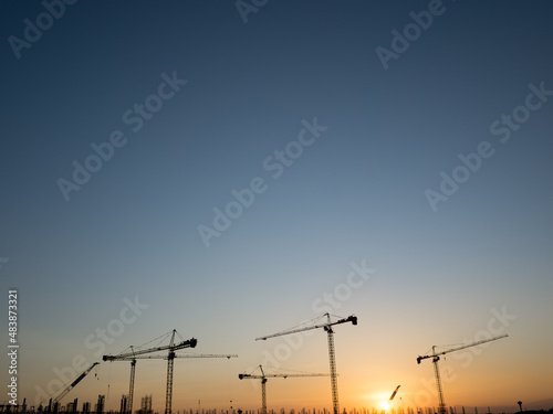 Cranes on a construction site, Silhouette of sunset