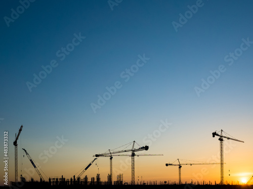 Cranes on a construction site, Silhouette of sunset