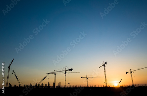 Cranes on a construction site, Silhouette of sunset