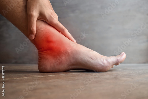 Inflammation of Asian man’s ankle joint and foot. Concept of joint pain, osteoarthritis or gout. photo