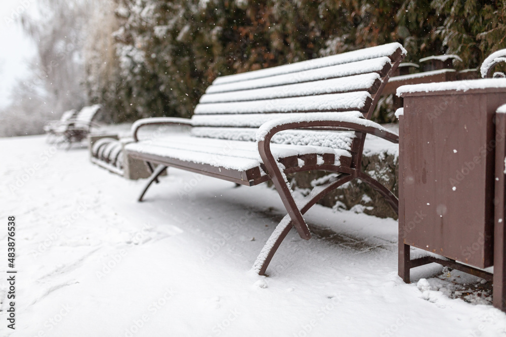 White snow on a park bench.