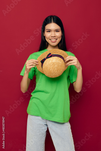 Portrait Asian beautiful young woman smile green t-shirt hat posing fashion red background unaltered