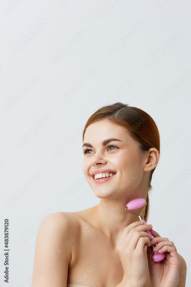 pretty woman pink quartz roller scraper skin care massage bare shoulders isolated background pretty woman pink quartz roller scraper skin care massage bare shoulders isolated background
