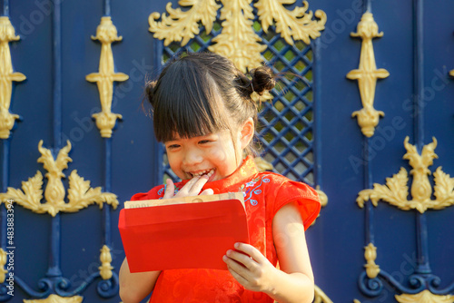 Asian cute girl wearing Chinese red dress holding Red envelope or Hong bao or Cheongsam. Chinese new year concept. photo