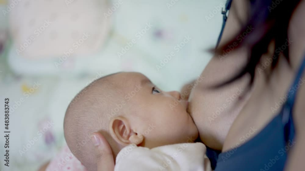 Adorable asian newborn, Mother breastfeeding and hugging baby. Baby eats milk after waking up. Lactation infant concept.