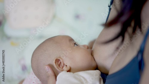 Adorable asian newborn, Mother breastfeeding and hugging baby. Baby eats milk after waking up. Lactation infant concept.