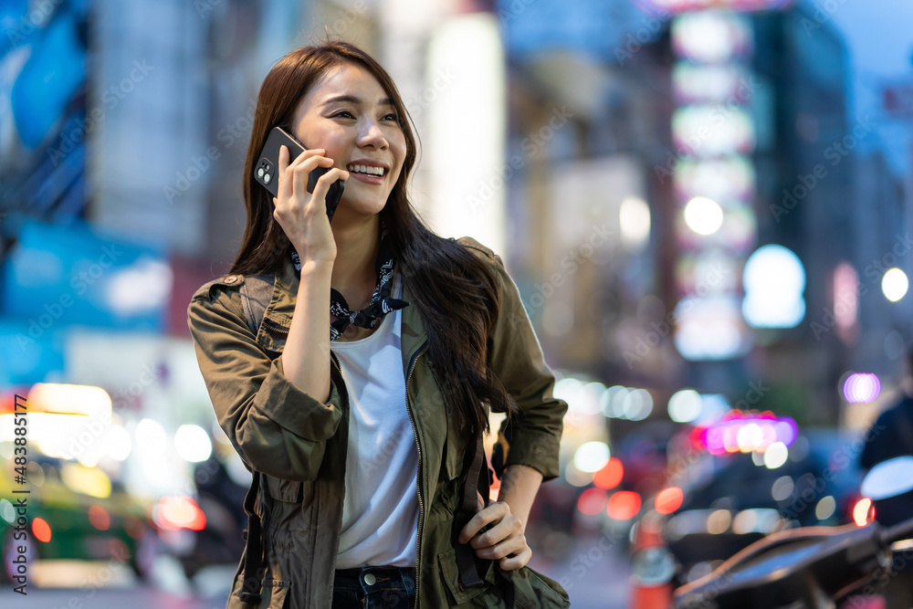 Fototapeta premium Asian attractive woman backpacker talking on mobile phone walk in city