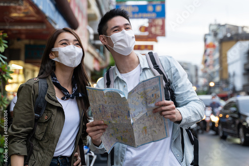 Asian romantic couple wear mask, travel in the city for honeymoon trip © Kawee