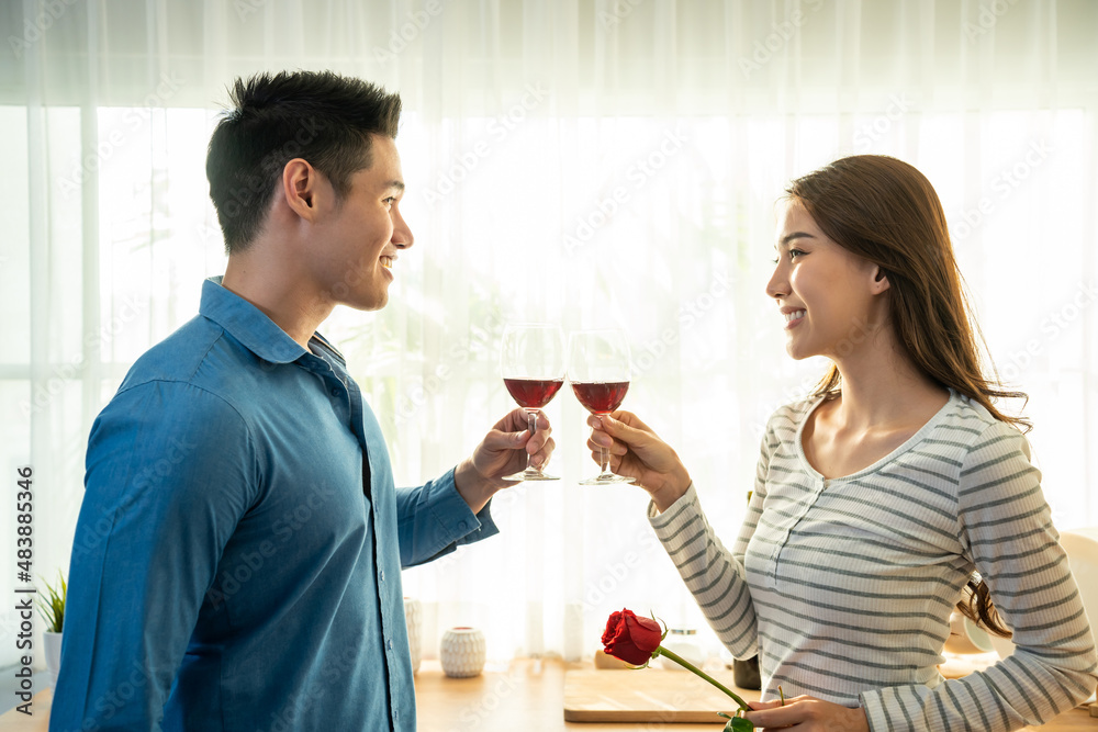 Asian young couple clinking glass of wine and drink on valentine's day Asian young couple clinking glass of wine and drink on valentine's day