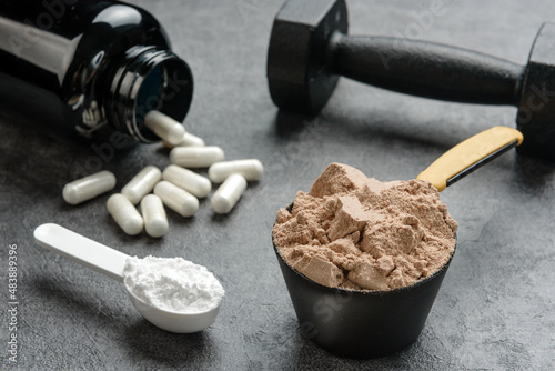 Chocolate flavored protein, creatine and amino acid capsules close-up. The concept of sports supplements. photo