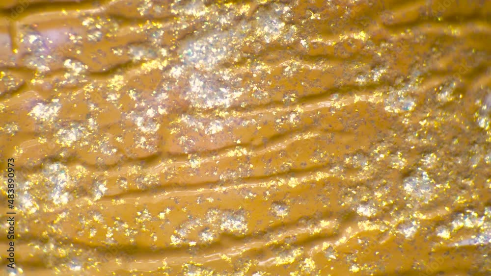 This stock video shows an abstract background with a veiny gold liquid and sparkly powder. This stock video shows an abstract background with a veiny gold liquid and sparkly powder.