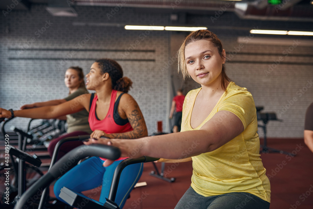 Girl look at camera while exercise on orbitrek