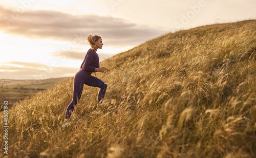 Woman running up hill in nature