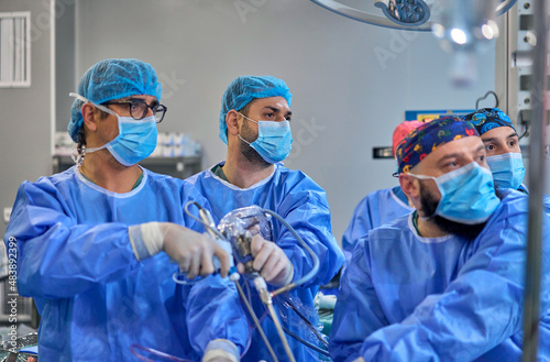 doctors in the operating room perform surgery on a patient photo