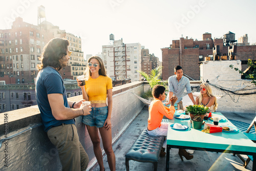 Photography Young happy people having a barbecue dinner on a rooftop in New York
