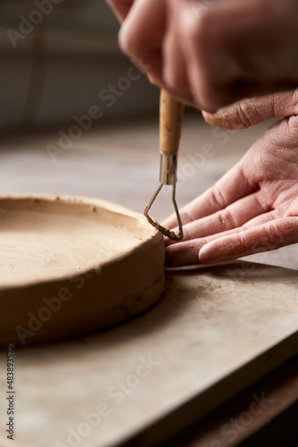 Female ceramist working in pottery studio. Ceramist's Hands Dirty Of Clay. Process of creating pottery. Master ceramist works in her studio