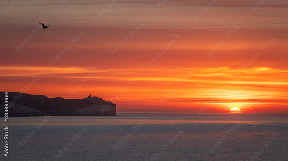 Colourful January sunrise from the cliff edge of Seaford Head looking out towards the Seven Sisters and Belle Tout lighthouse on the east Sussex coast, south east England Colourful January sunrise from the cliff edge of Seaford Head looking out towards the Seven Sisters and Belle Tout lighthouse on the east Sussex coast, south east England