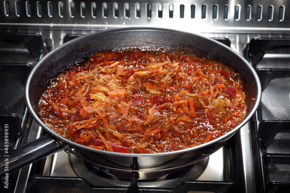 Homemade stewed cabbage with beetroot in a steel frying pan