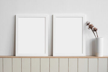 Two blank picture frames mockup on white wall. Templates for painting or poster. Living room interior design. View of modern rustic style interior with artwork mock-ups