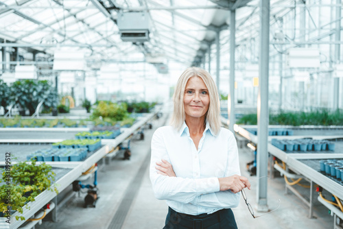 Confident scientist with arms crossed in plant nursery
