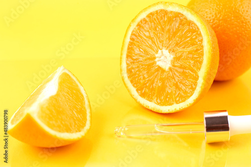 Pipette with orange essential oil over bottle and oranges. Natural medicine concept. Aromatherapy